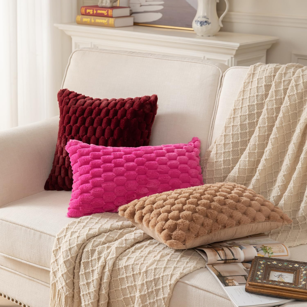 Housses de coussin bordeaux, fuchsia et marron sur un fauteuil clair