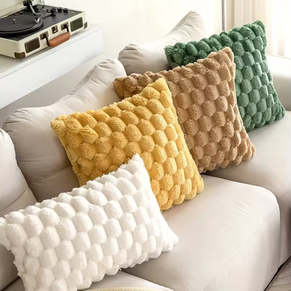 Housses de coussin blanche, jaune, marron et verte sur un canapé beige