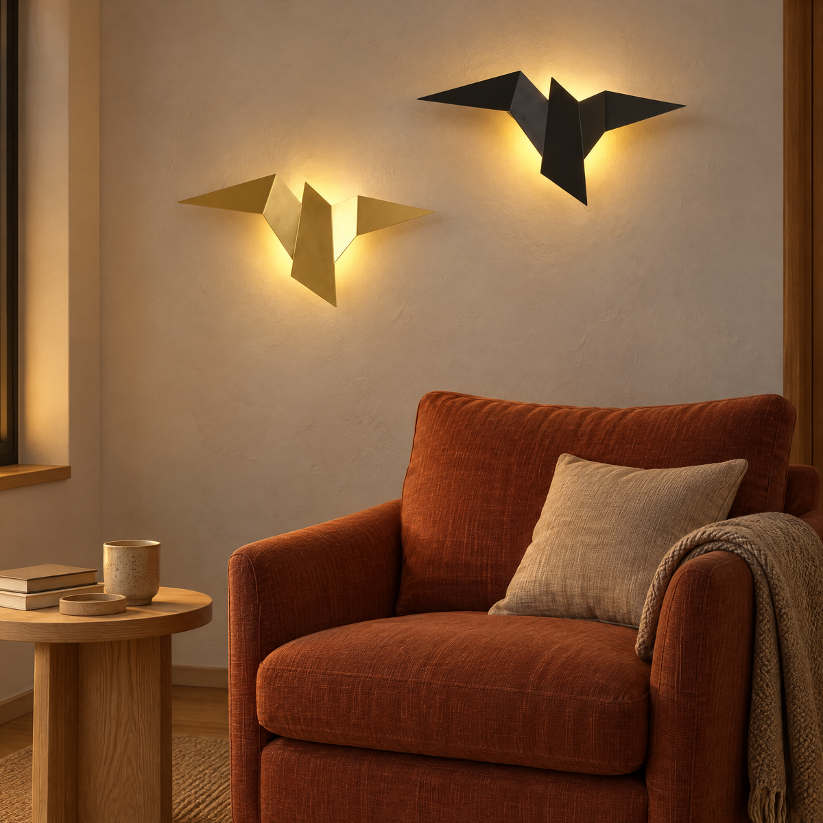 Deux appliques murales LED oiseau, dorée et noire, au-dessus d'un fauteuil dans un coin lecture