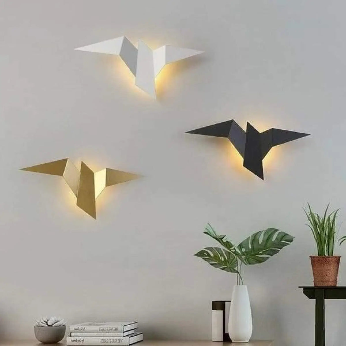 Appliques oiseau blanche, dorée et noire sur un mur du salon