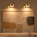 Applique murale sans fil dorée : deux appliques LED éclairent un grand tableau dans le salon