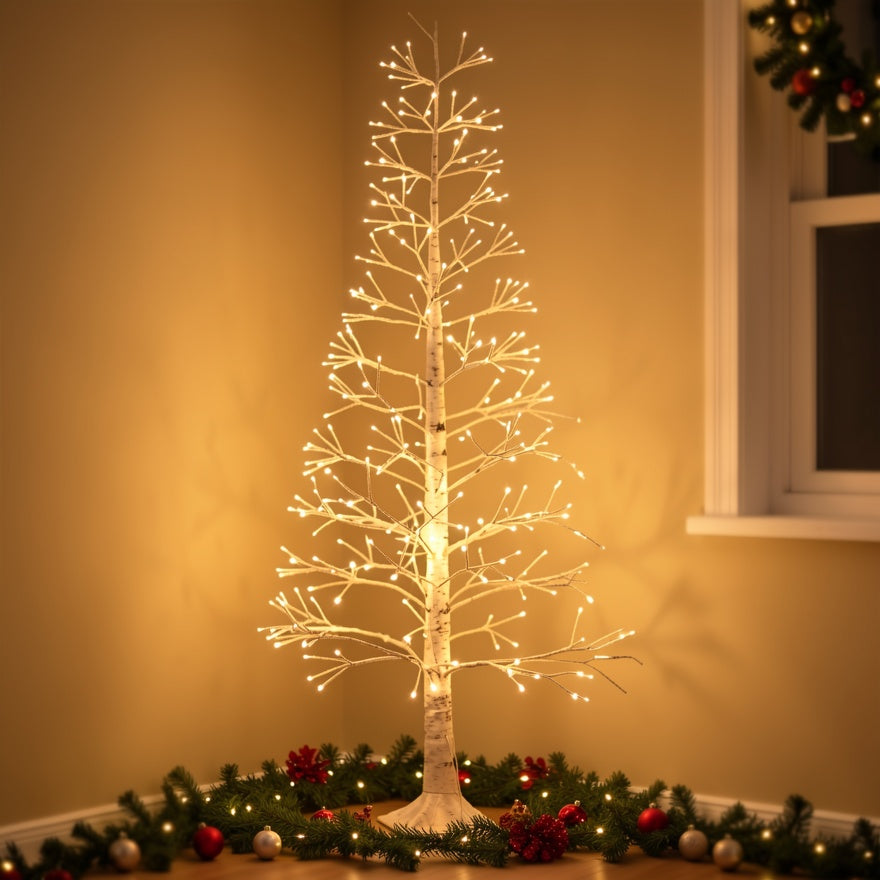 Arbre lumineux effet bouleau dans un angle de pièce, une guirlande de verdure à son pied