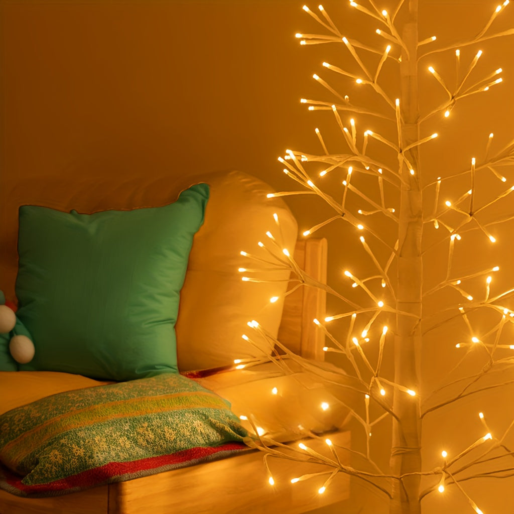 Branches lumineuses de l'arbre LED à côté d'un canapé avec un coussin vert