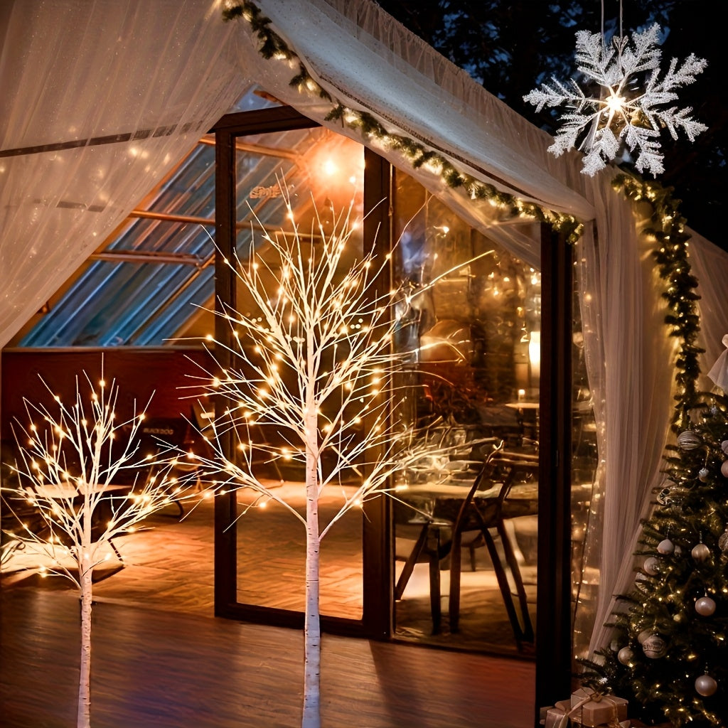 Deux arbres LED blancs façon bouleau dans une véranda illuminée pour les fêtes
