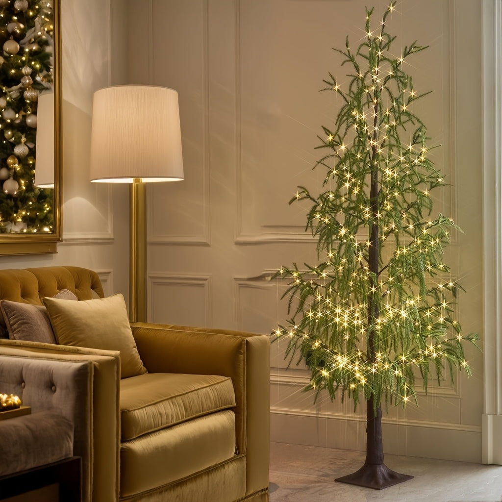 Arbre lumineux aux feuilles vertes à côté d'un fauteuil en velours et d'un lampadaire dans le salon