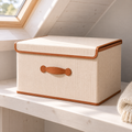 Boîte de rangement pliable beige avec couvercle sur une étagère en pin sous les combles