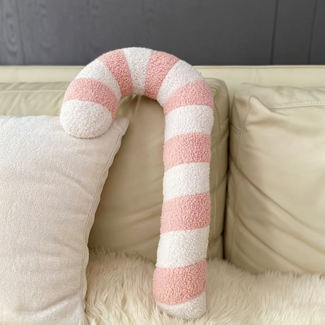 Coussin sucre d'orge rose sur un canapé avec un plaid en fourrure