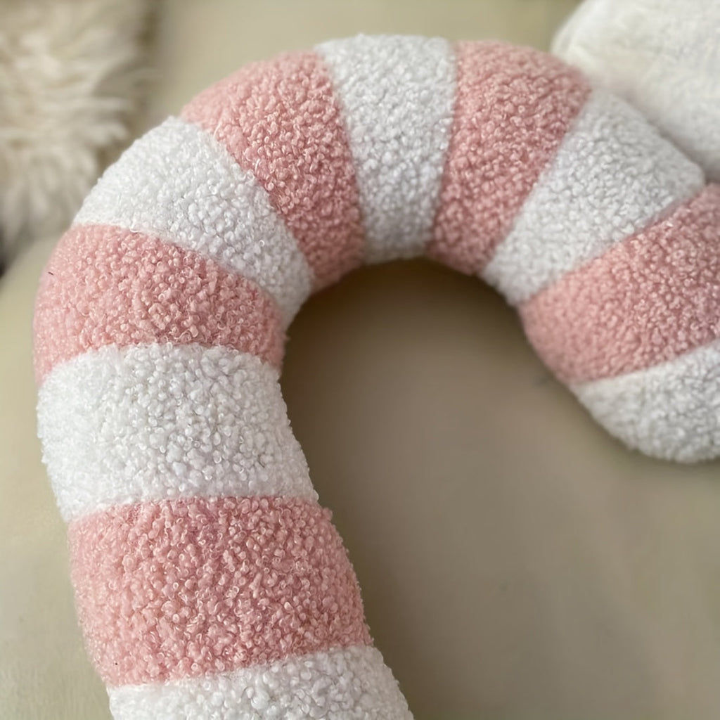Gros plan sur le coussin sucre d'orge rose en peluche