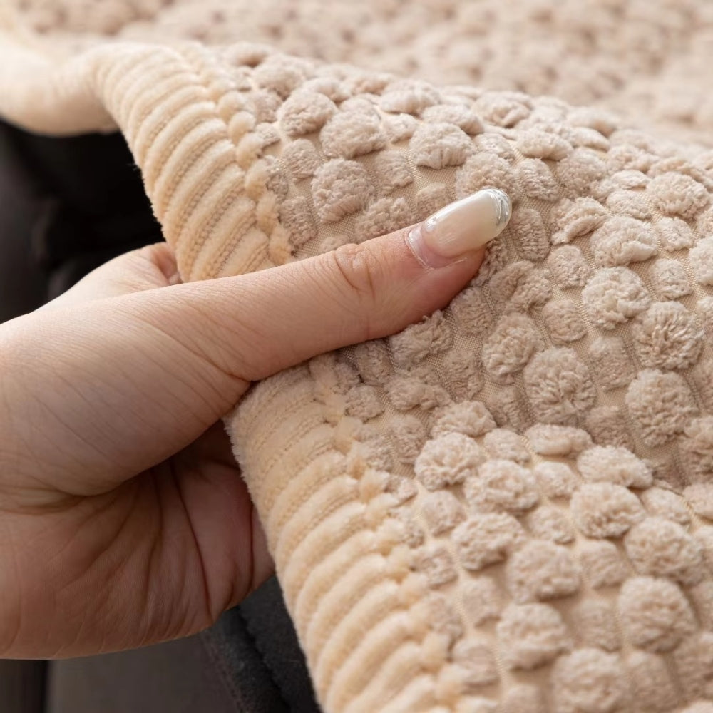 Main posée sur la texture matelassée du couvre canapé