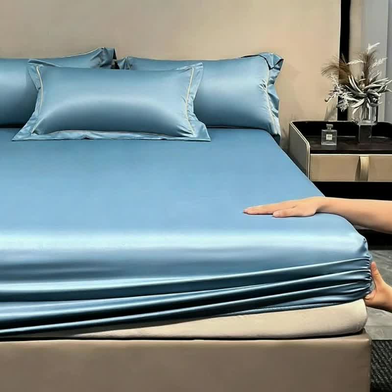 Main posée sur le drap-housse aspect satiné bleu tendu sur le matelas