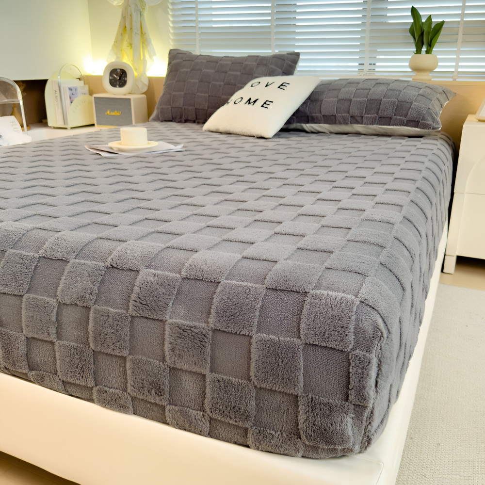 Coin de matelas avec le drap-housse gris, bonnet et élastique visibles