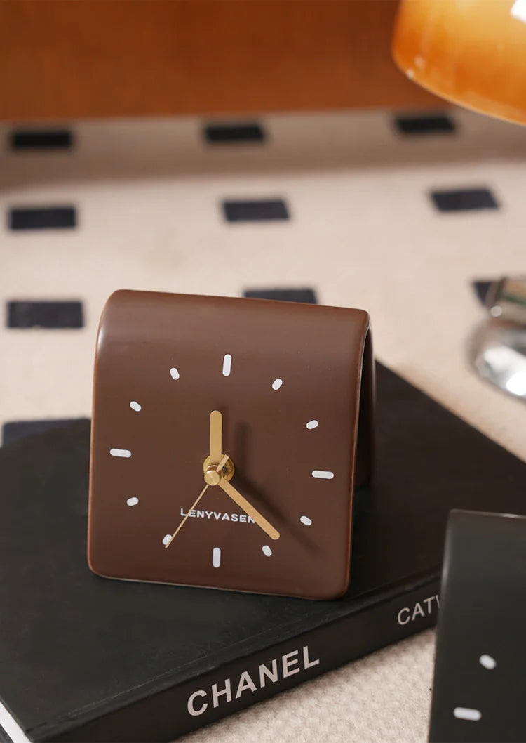 Horloge à poser marron sur un livre