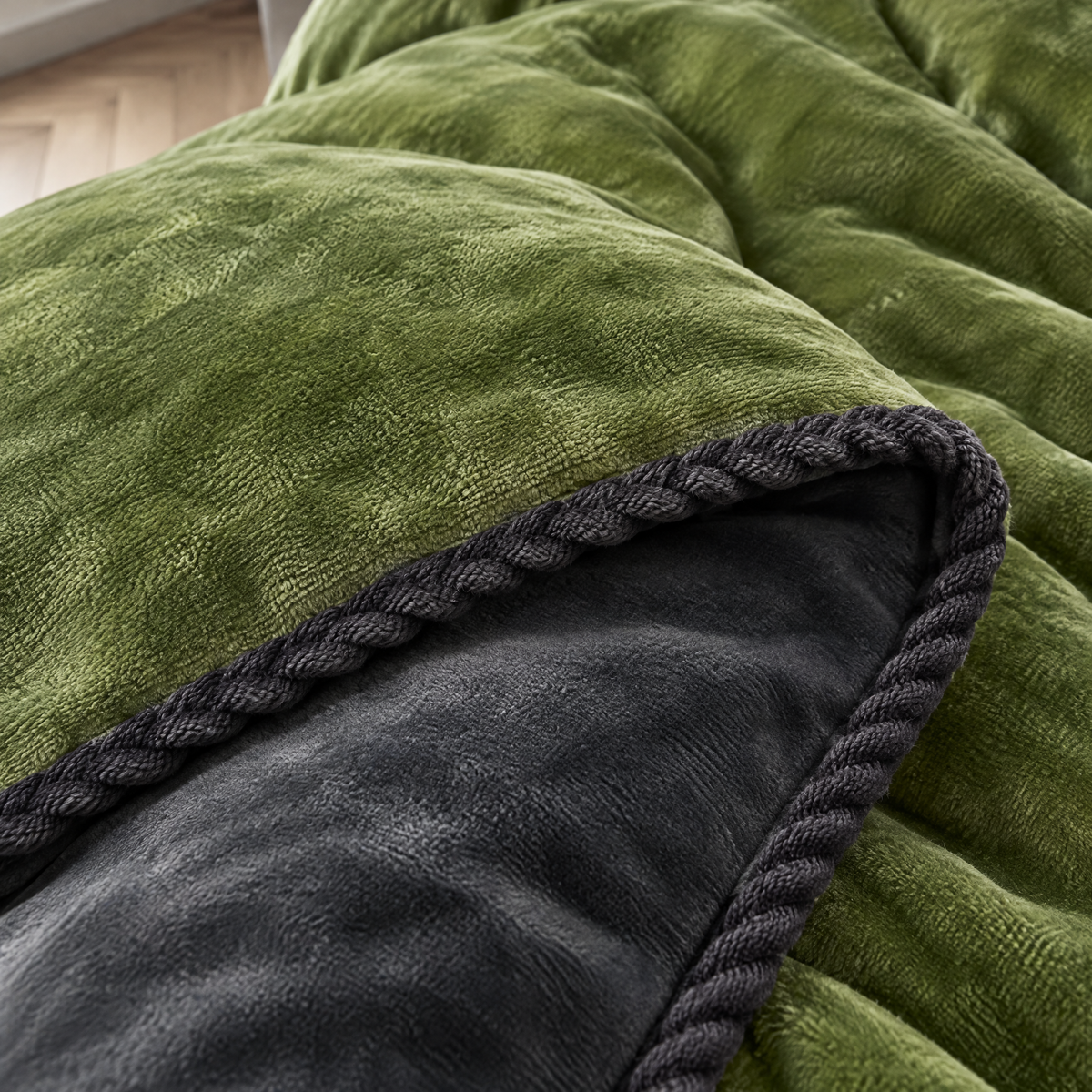 Gros plan de la housse de couette flanelle : flanelle brossée vert mousse, envers gris et bord tressé