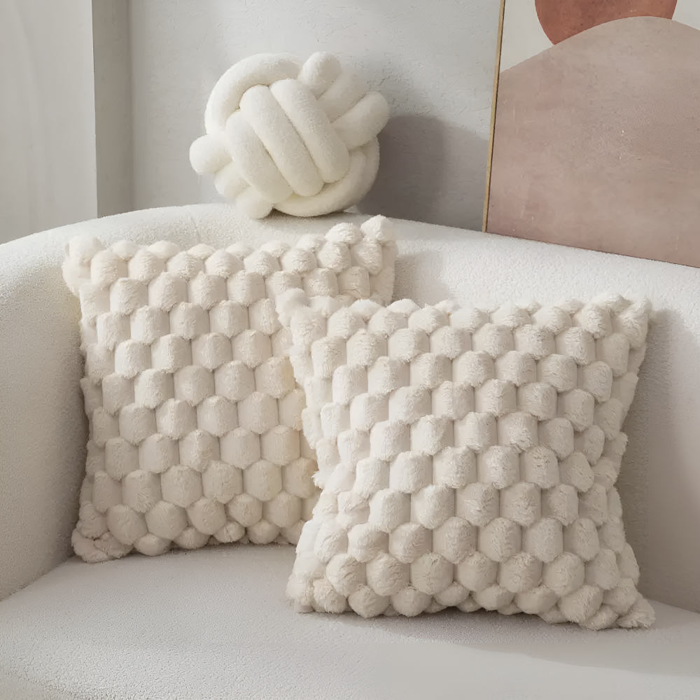Housses de coussin crème à relief bulles sur un canapé blanc
