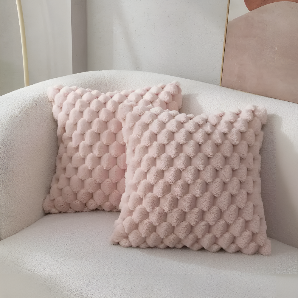Housses de coussin roses à relief bulles sur un canapé blanc