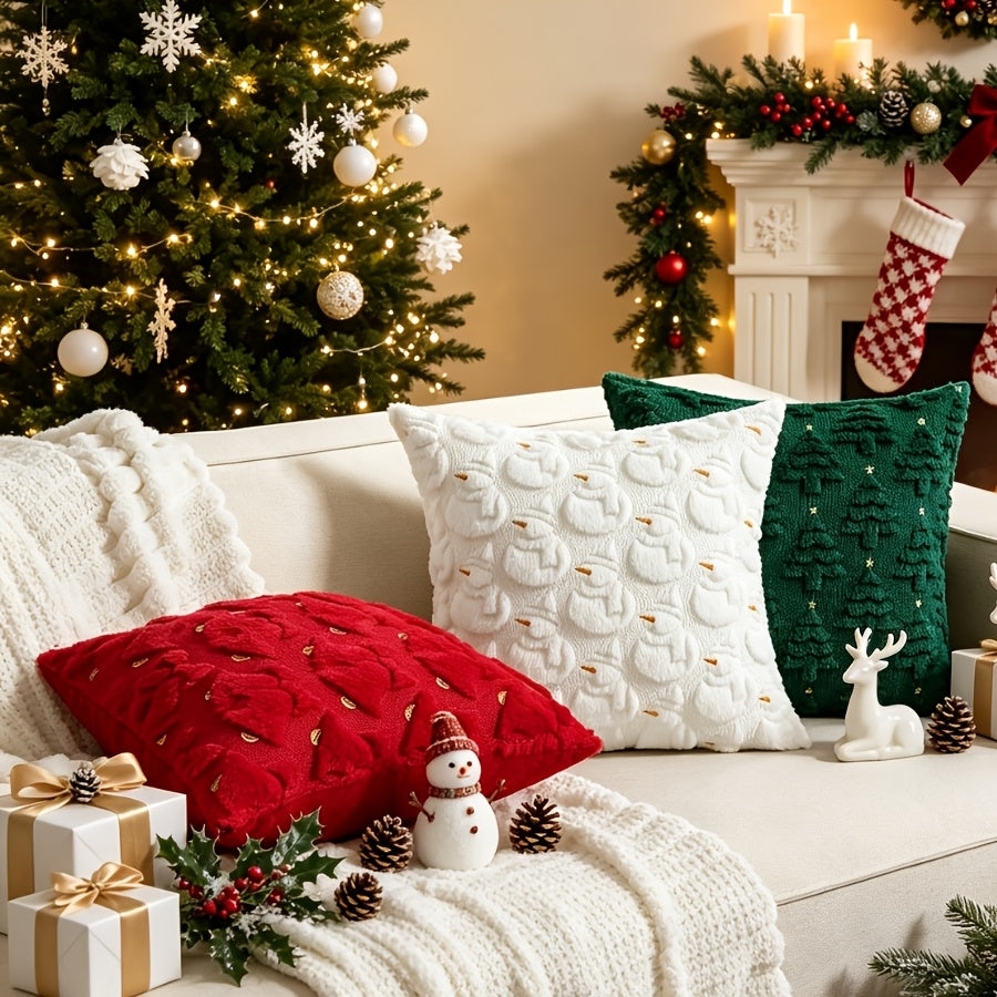 Housse rouge à cloches et housse verte à sapins sur un canapé devant la cheminée, avec un coussin blanc de décoration non vendu