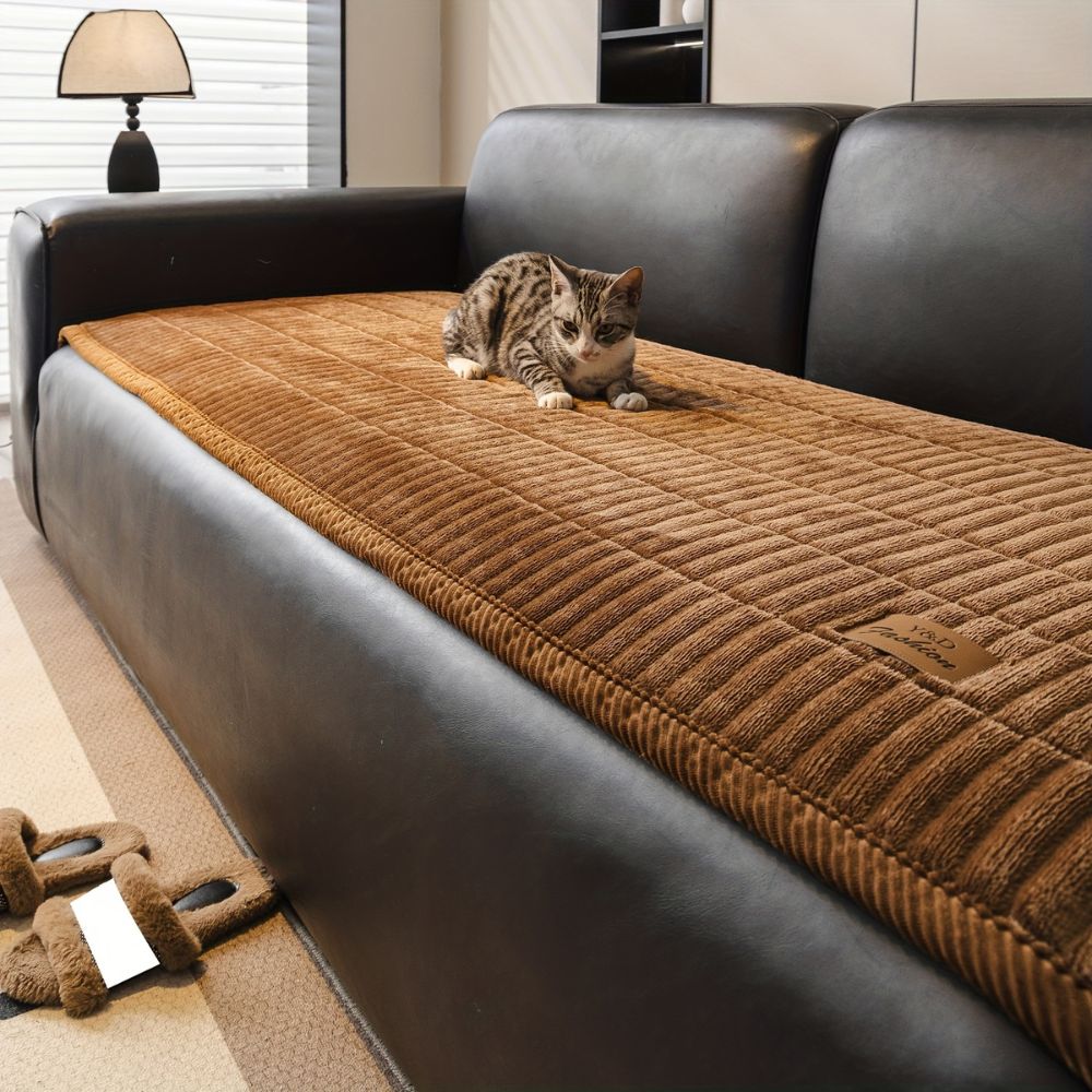 Jeté de canapé matelassé caramel avec un chaton sur l'assise