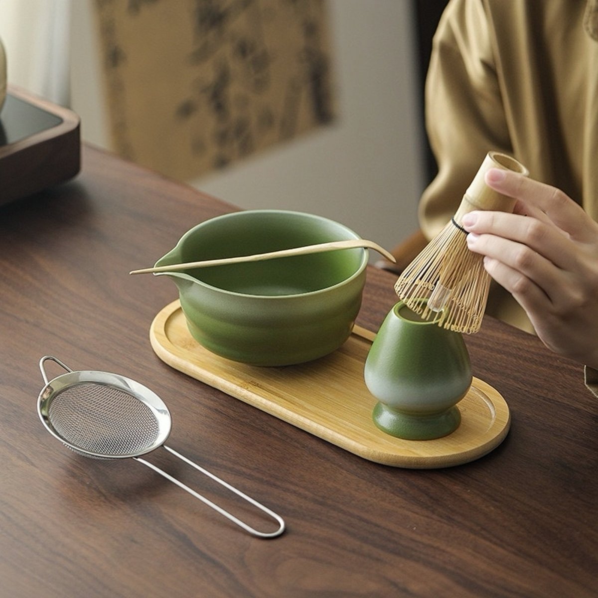 Bol et support de fouet vert mousse sur le plateau en bambou