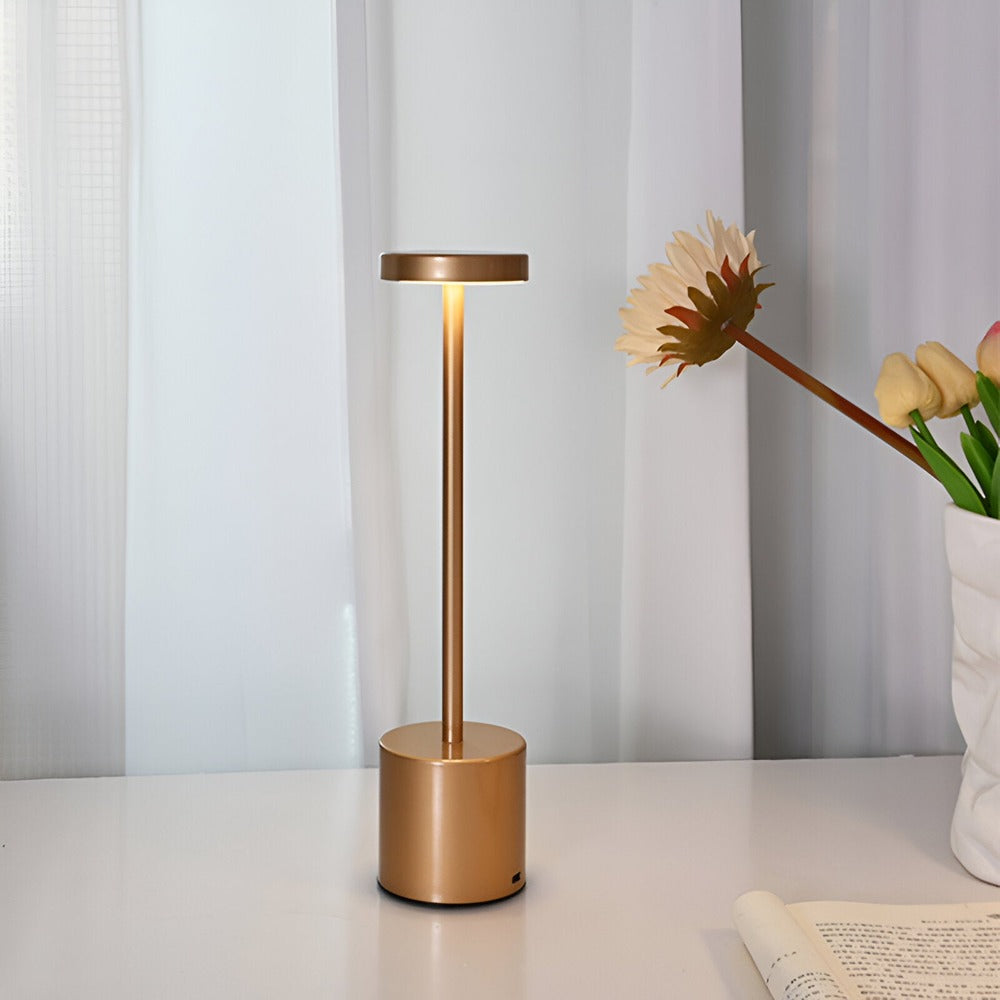 Lampe de table sans fil dorée sur une console près d'une fenêtre