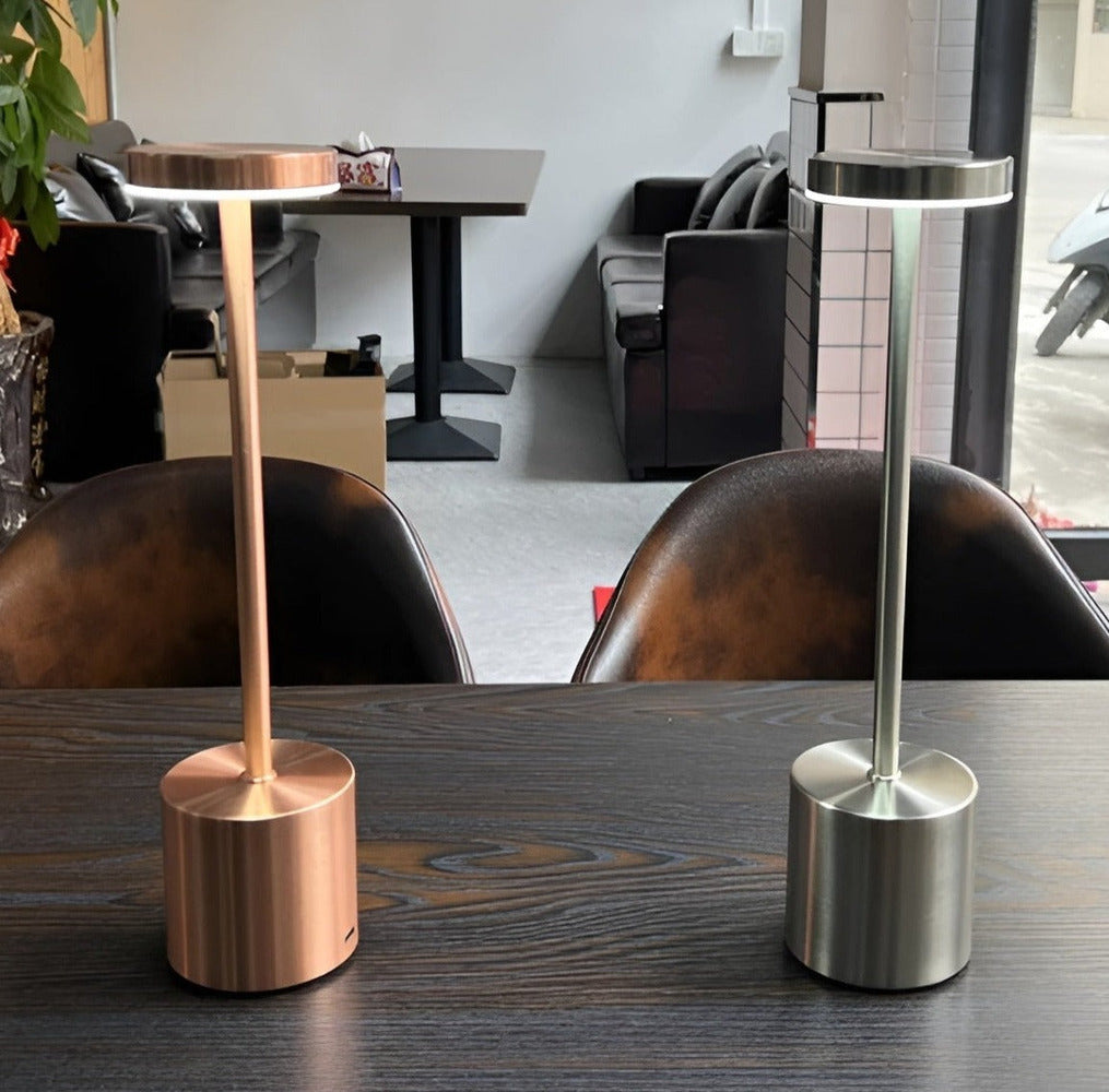 Lampes de table sans fil or rose et argentée sur une table en bois