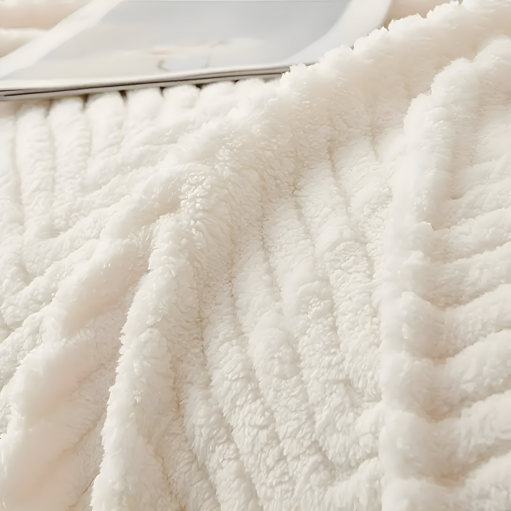 Gros plan sur la peluche moelleuse à motif chevron du plaid blanc