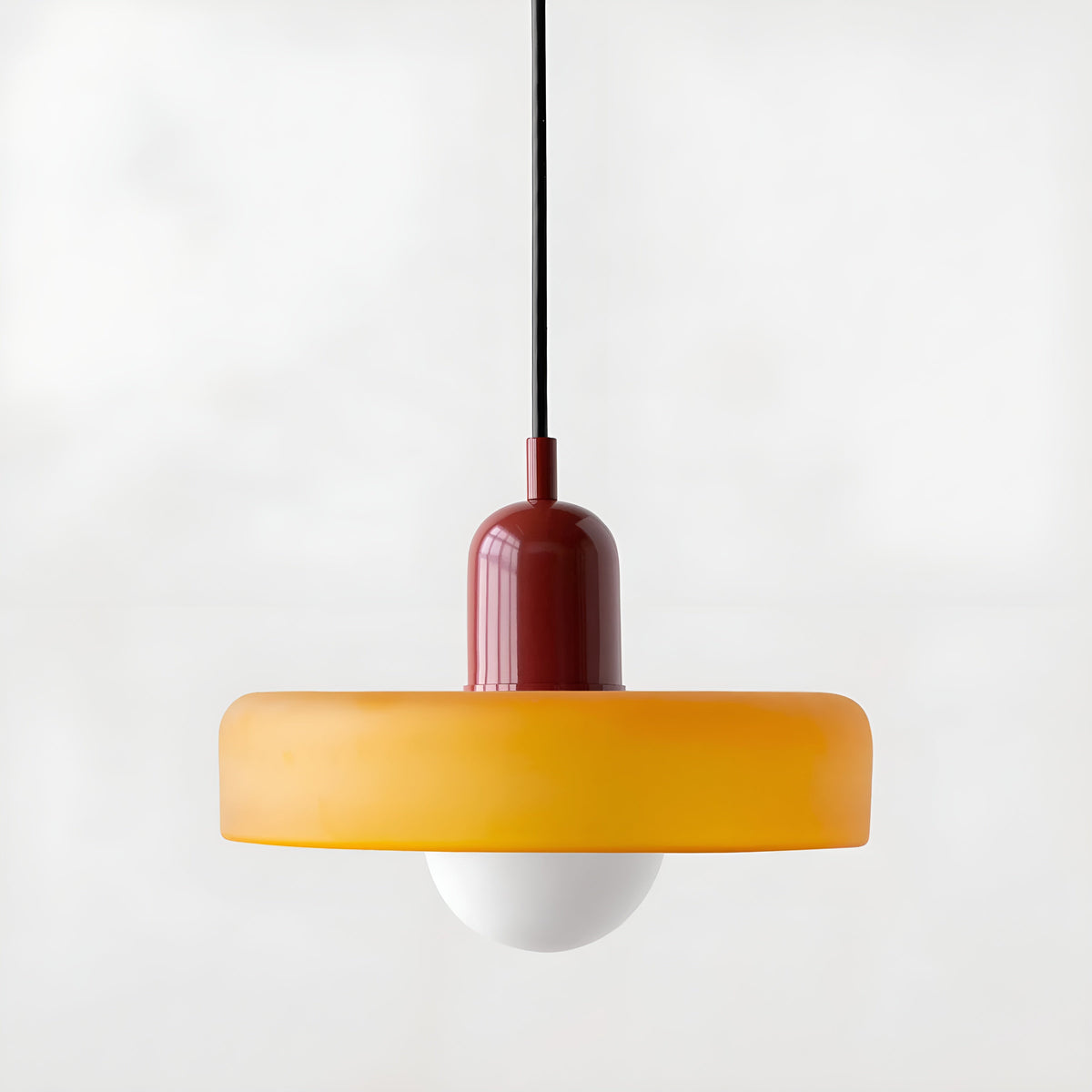 Suspension en verre jaune et monture bordeaux sur fond clair