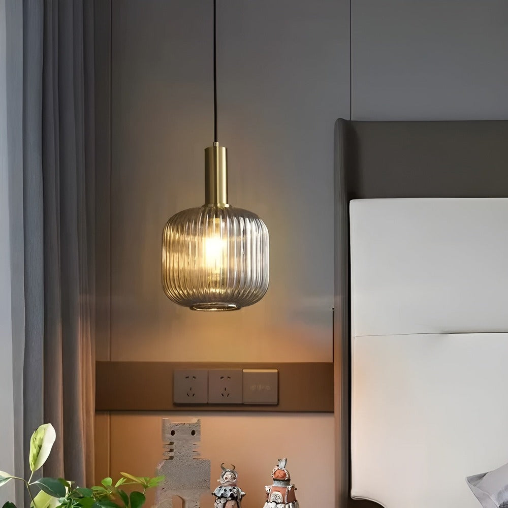 Suspension en verre strié gris fumé allumée près d'une tête de lit