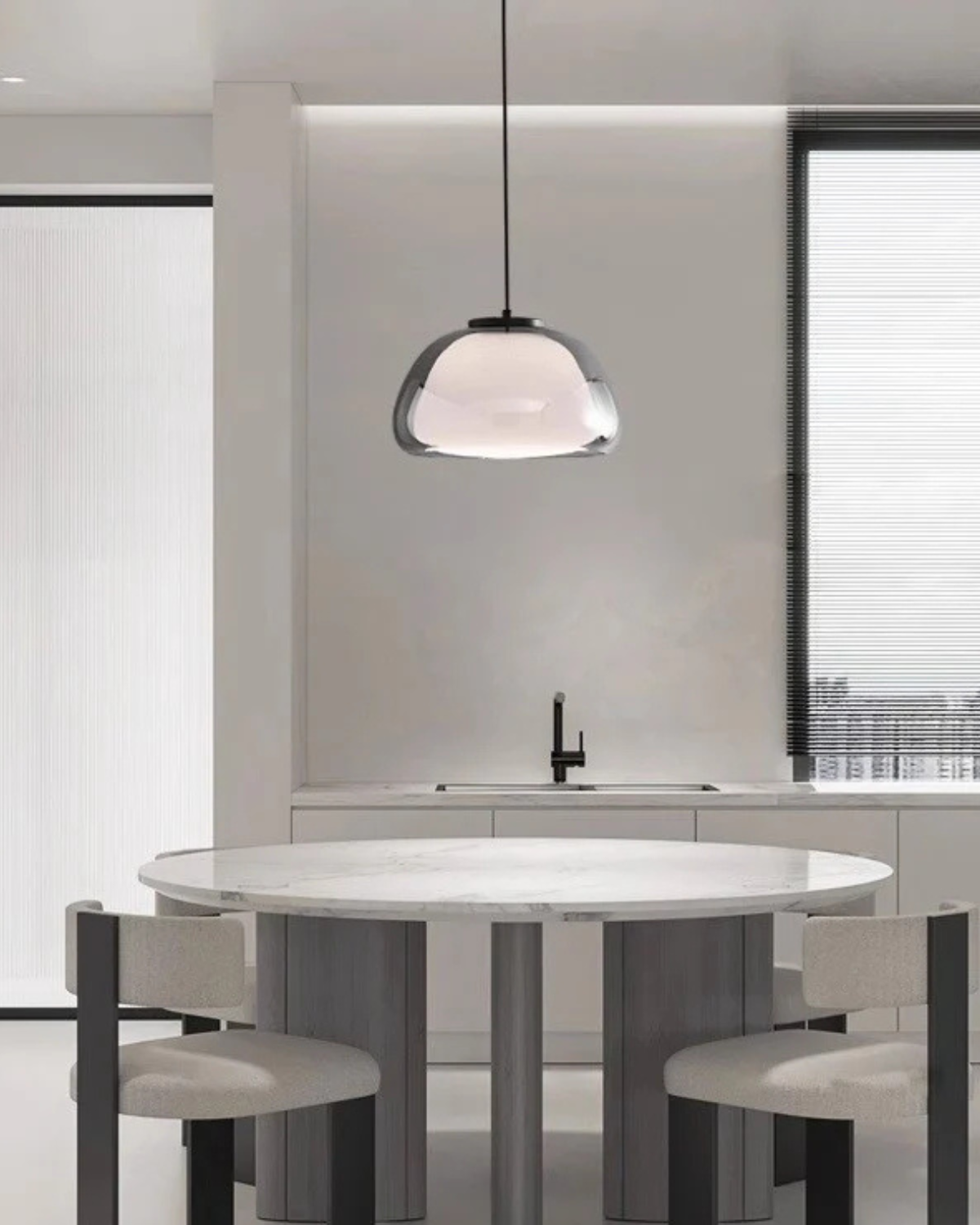 Suspension en verre fumé au-dessus d'une table ronde dans une cuisine claire