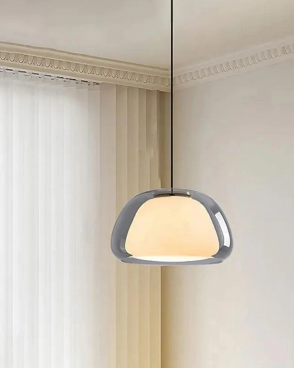 Suspension en verre fumé avec opaline devant des rideaux clairs