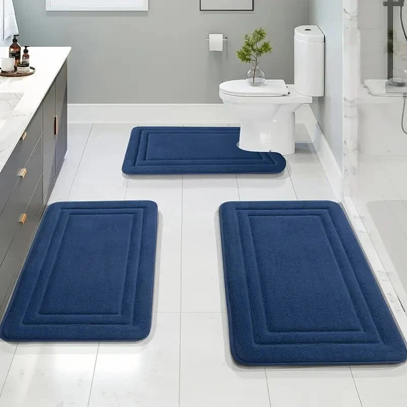 Lot de 3 tapis de bain bleu marine avec contour WC dans une salle de bain lumineuse