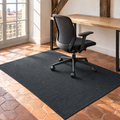 Tapis de chaise de bureau gris foncé sous un fauteuil de bureau sur tomettes