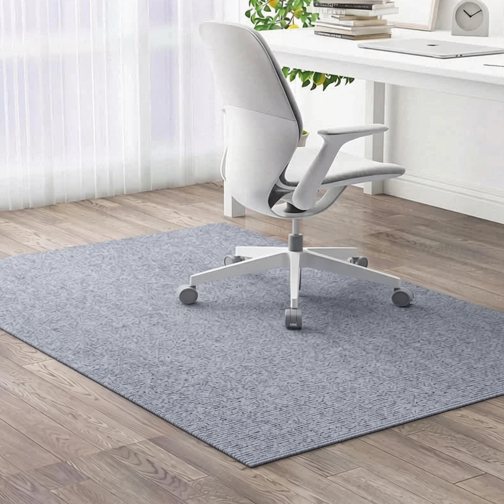 Tapis de chaise de bureau gris bleuté sous un fauteuil blanc près d'une fenêtre